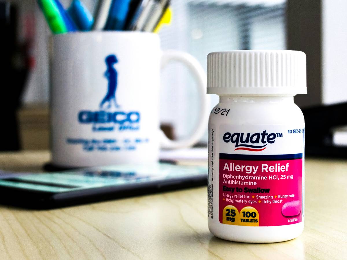 Allergy Relief Risk Assessments: Dog owner reviewing supplement label while veterinarian examines a scratching golden retriever
